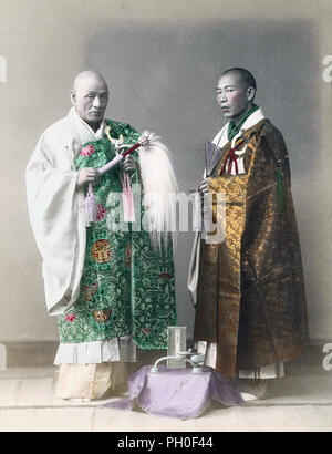 [ Giappone del 1890 - due sacerdoti buddisti ] - immagine studio di due sacerdoti buddisti. Il sacerdote a sinistra tiene perline di preghiera di Juzu e un Hossu (払子) con i capelli in pelo. L'altro indossa anche Juzu, e un ventilatore. Entrambi indossano una stola monaca, chiamata Kesa, fatta di sontuosa broccata di seta. fotografia albumen d'epoca del xix secolo. Foto Stock