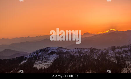 Sunrise attraverso Snow capped mountain in Kufri, Himachal Pradesh, India Foto Stock