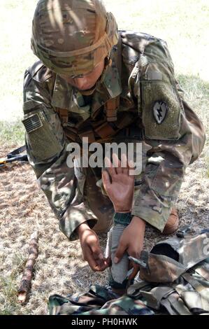 Pfc. Davis Blackwell, un fante assegnati al 2° Battaglione, 35th Reggimento di Fanteria, 3° Brigata Team di combattimento, XXV divisione di fanteria, esegue il primo soccorso in caso di ustioni durante l esperto di badge Fante test a Schofield Barracks, Hawaii, il 14 giugno 2018. Fanti in tutto il venticinquesimo ID partecipano a questo evento biennale per guadagnare il prestigioso esperto Fantassin Badge. Foto Stock