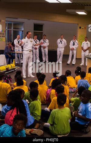 CHATTANOOGA, Tennessee (15 giugno 2018) della Cmdr. Paul Seitz, comandante, USS Tennessee (SSBN 734) Equipaggio di blu, e Broomfield, Colo., nativo, spiega cosa sottomarini sono simili ai bambini presso l'Highland Park Club per ragazzi e ragazze durante la Marina Militare di Chattanooga settimana. Navy settimane sono progettati per collegare il pubblico con i marinai della marina militare, i programmi e le apparecchiature in tutto il paese. Ogni anno, America's Navy viene a casa a circa 15 città in tutto il paese per mostrare gli Americani perché avente una forte Marina è critica per il modo americano di vita. Foto Stock