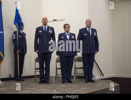 Col. Tim Donnellan, 124Fighter Wing Commander, Col. Stephanie Sheppard, l'uscita 124a sostegno delle missioni comandante del gruppo, e il tenente Col. Eric Newman, l'entrata 124MSG commander, stand presso l'attenzione come il colore delle marche di guardia durante la 124MSG cambiamento di cerimonia di comando Giugno 12, 2018 a Campo Gowen Boise, Idaho. La guardia d'onore è stato marciando per presentare i colori durante l'inno nazionale. Foto Stock