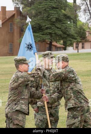 Il cap. Neil McCrery, il comandante uscente della sede centrale e sede società, U.S. Army Intelligence Center di eccellenza (USAICoE), passato il guidon al Col. Douglas Woodall, Capo del personale di USAICoE e Fort Huachuca, durante un cambio del comando cerimonia marrone sul campo di parata di giugno 15. Foto Stock