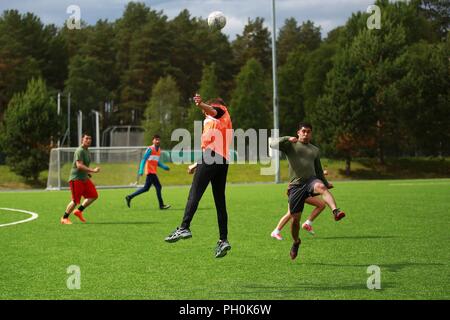 La British Royal Marines e U.S. Marines con Marine Force-Europe rotazionale 18.1 hanno gareggiato in una partita di calcio contro i soldati norvegesi con Home Guard 12 a Stordal, Norvegia, 15 giugno 2018. I marines segnato tre gol nella seconda metà per legare la partita a 4-4. Il gioco è solo una delle molte comunità e gli eventi di formazione i Marines prevedono di condurre con i loro alleati della NATO. Foto Stock