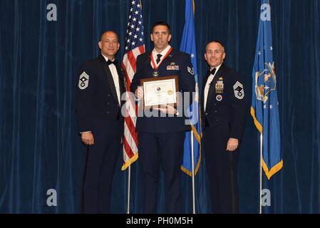 Il personale Sgt. Andrew Manca, dal 143disponibilità logistica Squadron, riceve l'illustre laureato Award per Airman leadership school Blended Learning corso 18-7 classe dal Chief Master Sgt. Ed Walden, il comando Capo Comandante Sergente dell'136Airlift Wing, e Chief Master Sgt. Winfield Hinkley, Comandante della Paolo H. Lankford arruolato Centro PME, qui, 15 giugno 2018 all'I.G. Brown di formazione e istruzione nel centro di Louisville, Tennessee L'illustre laureato Award è presentato al top 10 percento della classe. Foto Stock