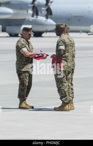 Stati Uniti Marine Corps Lt. Col. Andrew Pushart, comandante della antenna Marine Refueler squadrone di trasporto (VMGR) 152, destra presenta un U.S. Bandiera a Sgt. Il Mag. Laureano Perez Jr., Ex sergente maggiore di VMGR-152, al Marine Corps Air station Iwakuni, Giappone, 15 giugno 2018. Lo squadrone ha ospitato un post e cerimonia di sfiato al fine di riconoscere formalmente il totale trasferimento di autorità da Perez a U.S. Marine Corps Sgt. Il Mag. Charles Tyler, sergente maggiore di VMGR-152. Foto Stock