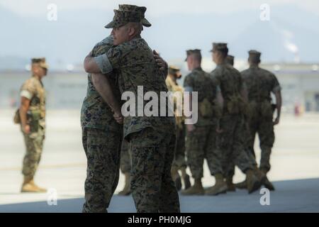 Stati Uniti Marine Corps Sgt. Il Mag. Laureano Perez Jr., Ex sergente maggiore di antenna Marine Refueler squadrone di trasporto (VMGR) 152, destra, congedandosi da U.S. Marine Corps Lt. Col. Andrew Pushart, comandante della VMGR-152, al Marine Corps Air Station Iwakuni, Giappone, 15 giugno 2018. Lo squadrone ha ospitato un post e cerimonia di sfiato al fine di riconoscere formalmente il totale trasferimento di autorità da Perez a U.S. Marine Corps Sgt. Il Mag. Charles Tyler, sergente maggiore di VMGR-152. Foto Stock