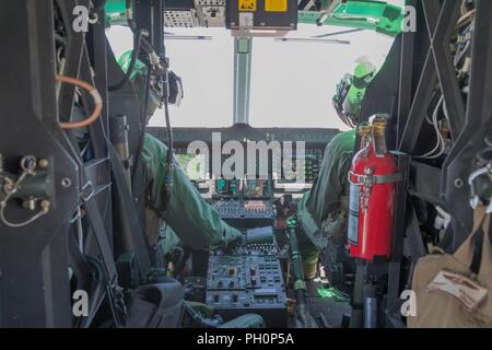 Il Mag. Contrassegnare Mauberret (sinistra) e il Mag. Brett Morriss (a destra), UH-1Y Venom piloti con Marine Attacco leggero elicottero Squadron 775, Marine Aircraft Group 41, quarto aeromobile Marina Wing, prepararsi a condurre a chiudere il supporto aereo missione, durante la formazione integrata esercizio 4-18 al Marine Corps Air Ground Centro di combattimento ventinove Palms, California, 18 giugno 2018. HMLA-775, noto anche come "Coyote, " di cui il combattimento aereo di supporto di elemento a Marina di Massa aria Task Force 23 durante l'ITX 4-18. Foto Stock