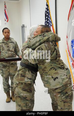 Stati Uniti La riserva di esercito Col. Regina Powell, il comandante uscente, rinuncia a comando per Col. Todd Traver durante un cambio del comando cerimonia presieduta da riserva di esercito Comando medico comandante generale, il Mag. Gen. Maria Link, tenuto lunedì, 18 giugno 2018 a Forest Park, Georgia. La modifica del comando cerimonia simboleggia il proseguimento della leadership di unità e identità nonostante il cambio delle singole autorità. Esso rappresenta anche il trasferimento di potenza da un leader di un altro; passando il cerimoniale di bandiera da in uscita al comandante in arrivo è la rappresentazione fisica di tale trasferimento. Foto Stock