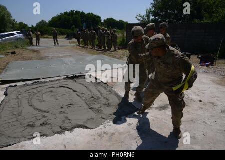 Stati Uniti Paracadutisti dell'esercito assegnato al Bravo Company, 54th ingegnere vigili del Battaglione, 173rd Brigata Aerea, collocare la piastra di copertura durante la luce airfield riparazione e cratere di formazione di riparazione con la elevata mobilità Engineer escavatore (HMEE) vicino a Trecenta , Rovigo, 20 giugno 2018. Il 173rd Brigata Aerea, con sede in Vicenza, Italia, è l'U.S. Esercito di risposta di emergenza forza in Europa, in grado di proiettare le forze per condurre la gamma completa delle operazioni militari su tutto il territorio degli Stati Uniti, europeo centrale e comandi Africa aree di responsabilità. Foto Stock