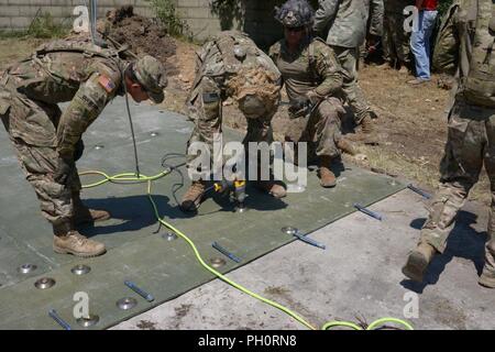 Stati Uniti Paracadutisti dell'esercito assegnato al Bravo Company, 54th ingegnere vigili del Battaglione, 173rd Brigata Aerea, collocare la piastra di copertura durante la luce airfield riparazione e cratere di formazione di riparazione con la elevata mobilità Engineer escavatore (HMEE) vicino a Trecenta , Rovigo, 20 giugno 2018. Il 173rd Brigata Aerea, con sede in Vicenza, Italia, è l'U.S. Esercito di risposta di emergenza forza in Europa, in grado di proiettare le forze per condurre la gamma completa delle operazioni militari su tutto il territorio degli Stati Uniti, europeo centrale e comandi Africa aree di responsabilità. Foto Stock