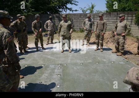 Stati Uniti Paracadutisti dell'esercito assegnato al Bravo Company, 54th ingegnere vigili del Battaglione, 173rd Brigata Aerea, durante un ultimo breve dopo che la luce airfield riparazione e cratere di formazione di riparazione con la elevata mobilità Engineer escavatore (HMEE) vicino a Trecenta , Rovigo, 20 giugno 2018. Il 173rd Brigata Aerea, con sede in Vicenza, Italia, è l'U.S. Esercito di risposta di emergenza forza in Europa, in grado di proiettare le forze per condurre la gamma completa delle operazioni militari su tutto il territorio degli Stati Uniti, europeo centrale e comandi Africa aree di responsabilità. Foto Stock