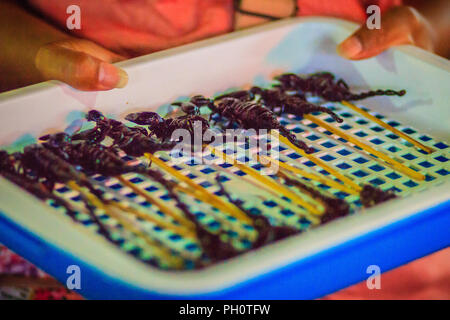 Produttore tailandese è la vendita di scorpione arrosto su strada a Bangkok il mercato notturno, Thailandia. Foto Stock