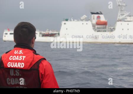 Un membro di equipaggio del USCGC Alex Haley (WMEC 39) si erge lookout durante un trasferimento di custodia di detenuti peschereccio da eseguire con la Repubblica popolare di Cina Coast Guard nel Mare del Giappone, 21 giugno 2018. L'Alex Haley e PRC Coast Guard equipaggi trattenuti la corsa da sospetta illegali di alto mare pesca con reti da posta derivanti. Foto Stock