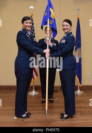 Stati Uniti Air Force Col. Debra Lovette, 81st formazione Wing Commander, passa la 81st Medical Group guidon al Col. Beatrice Dolihite, incoming 81st MDG commander, durante la 81st MDG modifica del comando cerimonia nella Bay Breeze Event Center a Keesler Air Force Base, Mississippi, 22 giugno 2018. Il passaggio del guidon è un simbolo di cerimoniale di scambiare il comando da un comandante di un'altra. Foto Stock