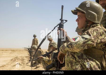 Provincia di Helmand, Afghanistan (20 giugno 2018) - Esercito nazionale afgano 215th Corps soldati in attesa di ricevere la loro munizioni prima di cominciare la loro formazione durante un live-Incendio campo a Camp Shorabak. Questa è la prima volta ANA militari hanno sparato live turni durante la conduzione di attacchi di squadra durante un esercizio di formazione come parte della fattibilità operativa ciclo, che è un segmento di formazione progettate per migliorare ANA soldati di fanteria" le competenze e rafforzare l unità complessiva efficacia. Foto Stock