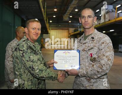 Supporto navale attività BAHRAIN (25 giugno 2018) DEGLI STATI UNITI Navy Cmdr. Daniel Brown, Naval Amphibious vigore, Task Force 51/5th Marine Expeditionary Brigade direttore della Direzione Logistica, presenta U.S. Master Marine Sgt. William J. Tolleson con il servizio meritevole medaglia (stella d'oro al posto della seconda award) per il suo eccellente servizio meritorio mentre serve come contratto operativo capo di supporto da luglio 2016 a giugno 2018. Come il comando del contraente solitario esperto ha negoziato e gestito il supporto di vita e il supporto di contratti a sostegno di ansiosi Lion 2017 e 2018 per salvare il comando o Foto Stock