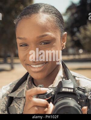 Stati Uniti Air Force Airman 1. Classe Alessandria Lee, 100th Air Refuelling ala affari pubblici fotoreporter, pone con la sua fotocamera a RAF Mildenhall, Inghilterra, 25 giugno 2018. Lee ha aderito la Air Force nel dicembre 2016 ed è un nativo di Chicago. Foto Stock