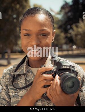 Stati Uniti Air Force Airman 1. Classe Alessandria Lee, 100th Air Refuelling ala affari pubblici fotoreporter, pone con la sua fotocamera a RAF Mildenhall, Inghilterra, 25 giugno 2018. Lee ha aderito la Air Force nel dicembre 2016 ed è un nativo di Chicago. Foto Stock