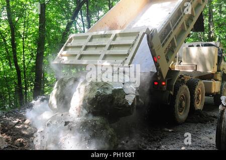 Una 10-tonnellata camion carichi di off massi a canale sotterraneo sito presso il Camp Dawson, West Virginia Giugno 20. Soldati da un ingegnere 662nd Supporto Azienda addestrata utilizzando una Hyex per caricare il dump trucks con massi durante il training annuale. Foto Stock