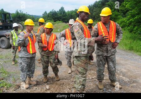 Sgt. 1. Classe Raynard Francesco, 662nd supporto tecnico dell azienda, spiega il lavoro svolto per il suo cantiere per le Isole Vergini Guardia nazionale capo del personale Col. Shawn Harris a Camp Dawson, West Virginia Giugno 21. Harris insieme con il 104th comando truppa comandante del battaglione magg. Nina Clarke-Brewley e il comando Sgt. Principali, Master Sgt. Pete Stapleton visitare l'azienda mentre sulla formazione annuale. Foto Stock