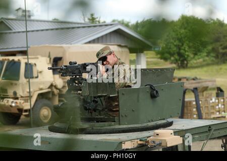 Cpl. Seth Tigner, un veicolo su ruote meccanico con il 211th impresa di manutenzione e nativo di leccare Valley, Ohio, coetanei giù i siti di ferro della sua M240B mitragliatrice prima di una mossa e scatta durante il corso di formazione annuale 24 Giugno presso il Camp Temolo manovra comune centro di addestramento di temoli, Mich I tiratori hanno dato un numero sufficiente di vivere le munizioni a fuoco 35 giri al bersaglio, a 45 bersagli di qualificarsi sul corso gunnery. Foto Stock