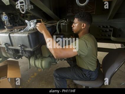 Sgt. Zachary Khordi attribuisce un mezzo tattico di sostituzione del veicolo MK23 standard carrello carico essiccatore di aria sul veicolo a Camp Kinser, Okinawa, in Giappone, 26 giugno 2018. Khordi, un automotive tecnico di manutenzione con il motore di trasporto e impresa di manutenzione, esegue la manutenzione preventiva su veicoli per mantenere l'integrità dei veicoli è intatto e garantire la sicurezza dei conducenti e dei loro occupanti. Khordi è un nativo di Cliffwood, New Jersey. Foto Stock