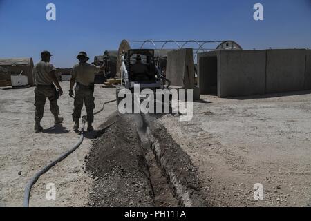 Stati Uniti Air Force aviatori assegnati alla 727th Expeditionary Air Control Squadron (EACS) e U.S. Le forze di aria di comando centrale A6 scavare una trincea per cavi alla loro postazione su una coalizione airfield nel nordest della Siria, Giugno 25, 2018. Il 727th EACS noto come "" del perno del fuso a snodo è compromesso di 14 campi di carriera che sono responsabili per il monitoraggio e la fornitura di aria vitale informazioni di immagine per garantire il completamento con successo di AFCENT giornaliero della Air ordine multitasking per le unità e i velivoli. Foto Stock