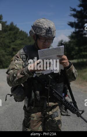 Stati Uniti Army Sgt. Ji Lu, assegnati al 9° chimica, biologica, radiologica, nucleare esplosivo (CBRNE) azienda, controlli le sue coordinate per la navigazione terrestre, Fort Dix, New Jersey, 20 giugno 2018. Il ventesimo CBRNE guerriero migliore concorrenza è una divisione concorso di livello che identifica un soldato e uno non ufficiale incaricato di procedere a FORSCOM del guerriero migliore concorrenza.( U.S. Esercito Foto Stock