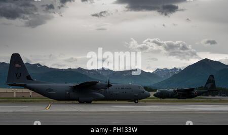 Stati Uniti Air Force C-130J Super Hercules aeromobile da Yokota Air Base, in Giappone e in Giappone Aria forza di autodifesa C-130H Hercules aeromobile da Hamamatsu Air Base, Giappone, pronti per il decollo durante il Red Flag-Alaska 18-2 operazioni alla base comune Elmendorf-Richardson, Alaska, 21 giugno 2018. RF-A è Pacific Air Forces " premier air combat esercizio che fornisce l'offensiva congiunta contro-aria, interdizione, chiudere il supporto aereo e la grande forza della formazione professionale in un combattimento simulato l'ambiente. Foto Stock