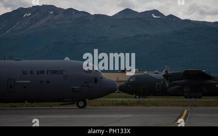 Stati Uniti Air Force C-130J Super Hercules aeromobile da Yokota Air Base, in Giappone e in Giappone Aria forza di autodifesa C-130H Hercules aeromobile da Hamamatsu Air Base, Giappone, pronti per il decollo durante il Red Flag-Alaska 18-2 operazioni alla base comune Elmendorf-Richardson, Alaska, 21 giugno 2018. RF-A è Pacific Air Forces " premier air combat esercizio che fornisce l'offensiva congiunta contro-aria, interdizione, chiudere il supporto aereo e la grande forza della formazione professionale in un combattimento simulato l'ambiente. Foto Stock