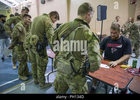 Soldati australiani, con Task Group Taji, ottenere autografi dai membri della National Football League e i falchi di Atlanta durante una visita a Camp Taji, Iraq, 18 giugno 2018. Taji Camp è uno dei quattro Combined Joint Task Force- operazione inerente risolvere la costruzione di capacità del partner location dedicate ai partner di formazione delle forze e il miglioramento della loro efficacia sul campo di battaglia. Foto Stock