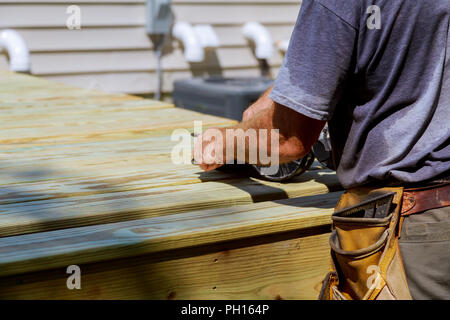 Backyard Deck ricostruzione uomo bello carpenter installazione pianale in legno terrazza all'aperto in casa di nuova costruzione Foto Stock