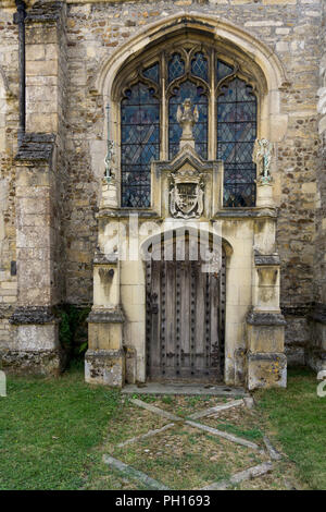 Vecchia porta di legno insieme in una cornice scolpita per la parte posteriore della chiesa di St Andrew, Kimbolton, Cambridgeshire, Regno Unito Foto Stock