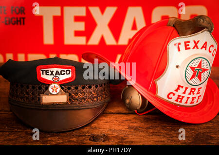 Un vintage Texaco assistenti di gas hat e un giocattolo di plastica Texaco Fire Chief casco. Foto Stock