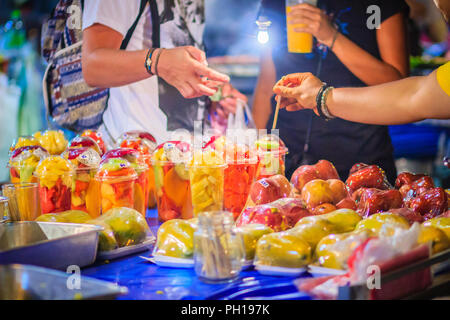 Close up street fornitore di frutta la vendita di frutta mista a Khao San Road mercato notturno, Bangkok, Thailandia. Foto Stock