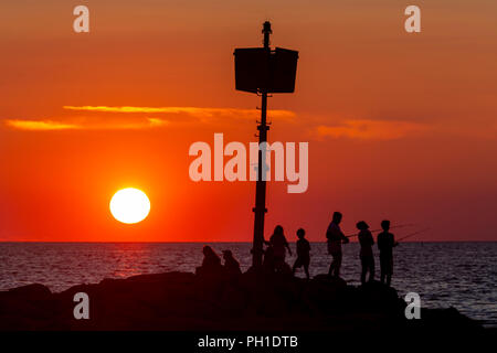 Le persone si mettono sul pontile, alcune attività di pesca e guardare il tramonto a Menemsha Beach in Chilmark, Massachusetts di Martha's Vineyard. Foto Stock