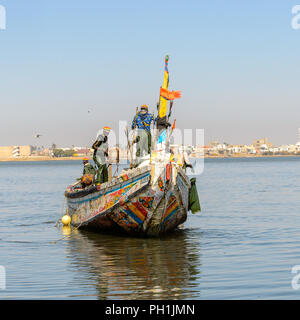 SAINT LOUIS, SENEGAL - Apr 24, 2017: Non identificato gli uomini senegalesi vela in una barca nel porto di Saint Louis, una delle più grandi città in Senegal Foto Stock