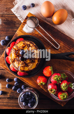 Vista dall'alto di una deliziosa colazione a base di frittelle servita con fragole e mirtilli Foto Stock