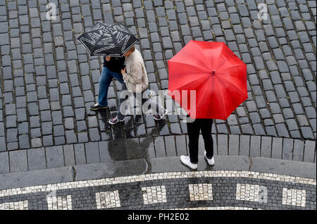 Praga, Repubblica Ceca. Il 30 agosto, 2018. Pedoni con ombrelloni passeggiata attraverso la Piazza della Città Vecchia di Praga, nella Repubblica ceca il 30 agosto 2018. Credito: Vit Simanek/CTK foto/Alamy Live News Foto Stock