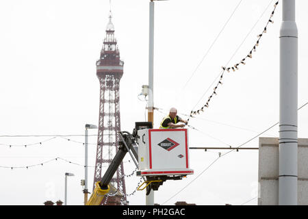 Blackpool , in Inghilterra. Xx Agosto , 2018. Tempo soleggiato oggi in Blackpool come alla fine della scorsa settimana di vacanze scolastiche estive si avvicina. Un operaio controlla uno degli oltre 1 milioni di bulbi precedendo le luminarie accendere domani. Credito: Chris Bull/Alamy Live News Foto Stock