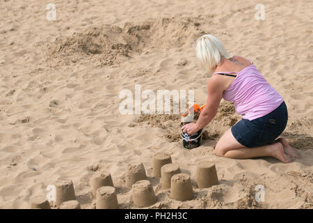 Donna che costruisce castelli di sabbia a Lytham Saint Anne's, Lancashire. Meteo Regno Unito 30/08/2018. I vacanzieri ritornano alle spiagge incontaminate mentre il clima caldo torna alla costa di Fylde. Le temperature sono previste per salire di nuovo questo fine settimana, come la Gran Bretagna è gode di un'altra mini Hat onda. Settembre potrebbe vedere alti di 30C con il tempo caldo che dura tutto il mese. Credit: MediaWorldImages/AlamyLiveNews Foto Stock