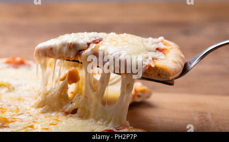 Close-up di un delizioso formaggio Pizza sul tavolo di legno Foto Stock