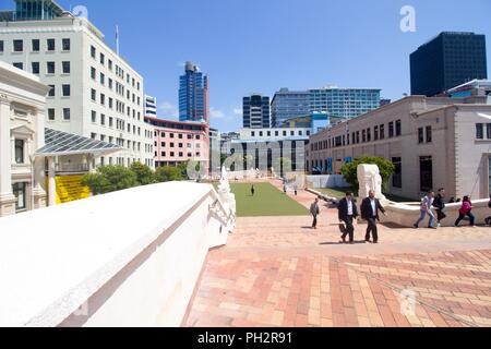 La gente a piedi attraverso Piazza Civica, con edifici visibile sullo sfondo, in Wellington, Nuova Zelanda, 28 novembre 2017. () Foto Stock