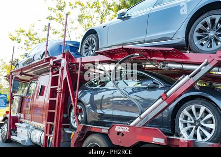 Nuovo di zecca Tesla Motors automobili elettriche, compreso il modello di Tesla 3 su un auto carrello portante in attesa di consegna vicino alla sede della società e la fabbrica in Silicon Valley, Fremont, California, 28 luglio 2018. () Foto Stock