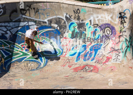 Giovane uomo lo skateboard in riva al fiume Fiume cantiere Skateboard Bowl, grande caduta, Montana, USA Foto Stock