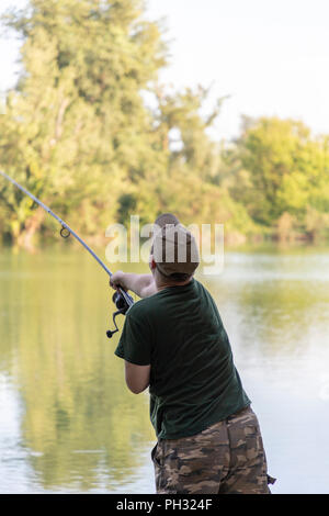 Pescatore in un lago carp fishing azione Foto Stock