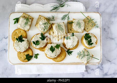 Snack da cracker e latticini pasta di pesce con erbe su uno sfondo luminoso. Foto Stock