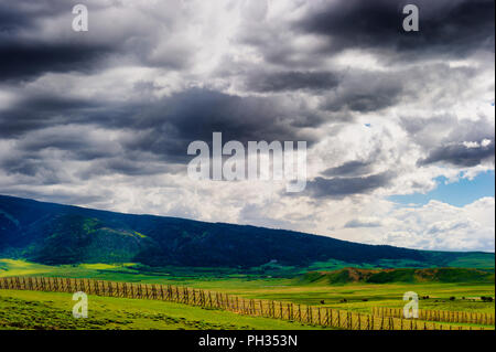 Viste del Wyoming infausto cieli nuvolosi su campi aperti e sezioni di Laramie Mountain Range, visto dalla strada statale 80 Foto Stock