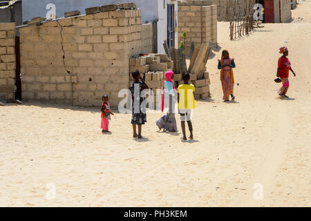 KAYAR, SENEGAL - Apr 27, 2017: Non identificato bambini senegalesi stare vicino al mucchio di mattoni in un bel villaggio vicino Kayar, Senegal Foto Stock