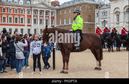London, Regno Unito - 29 Ottobre 2017: montato funzionario di polizia e di turisti al di fuori delle Guardie a Cavallo di Whitehall a Londra Foto Stock